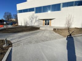 Commercial landscaping featuring a newly installed paved walkway and entrance area, showcasing McLeod Landscaping's hardscaping services and design expertise.
