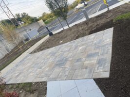 Commercial hardscaping installation featuring a newly paved stone walkway and landscaped area by McLeod Landscaping, showcasing quality workmanship and design.