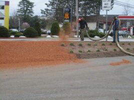 Two landscapers applying mulch in a commercial landscaping project, showcasing McLeod Landscaping's services.