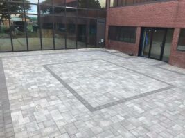 Commercial hardscaping installation featuring a paved outdoor area with a rectangular pattern, showcasing the quality of McLeod Landscaping's work in landscape design and construction.