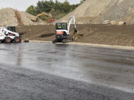 Excavation equipment operating on a commercial landscaping site, showcasing earthmoving and site preparation for landscaping projects.