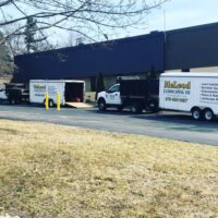 McLeod Landscaping service vehicles parked outside a commercial building, showcasing landscaping and snow management services.