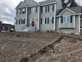 Residential landscaping project by McLeod Landscaping featuring a newly constructed home with a cleared yard ready for landscaping, showcasing potential for future garden and hardscaping installations.