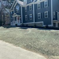 Residential landscaping project featuring a newly sodded lawn in front of a modern blue house with white trim, showcasing McLeod Landscaping's design and installation services.