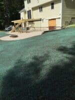 Residential landscaping project showcasing a well-maintained green lawn, patio area, and a house exterior, highlighting McLeod Landscaping's design and installation services.